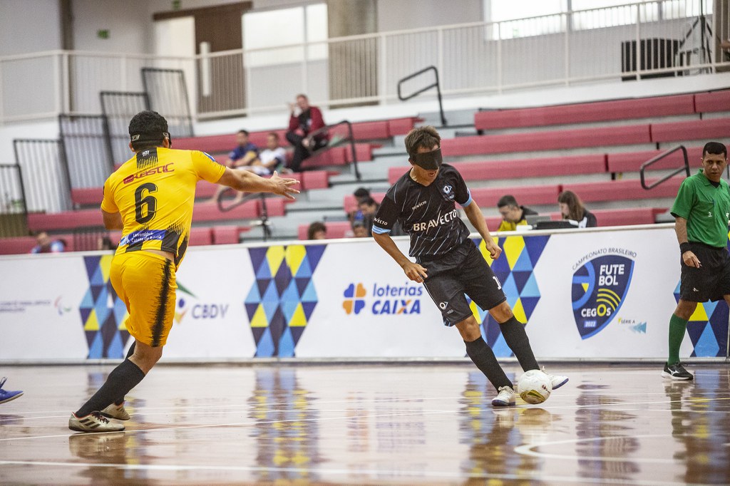Braian Pereyra INV x Uniace Brasileiro de futebol de cegos Braian Pereyra, de preto, conduz a bola enquanto é marcado por jogador da Uniace, de amarelo